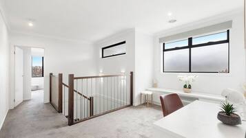 A modern interior with a staircase, a desk, and a window with a view.