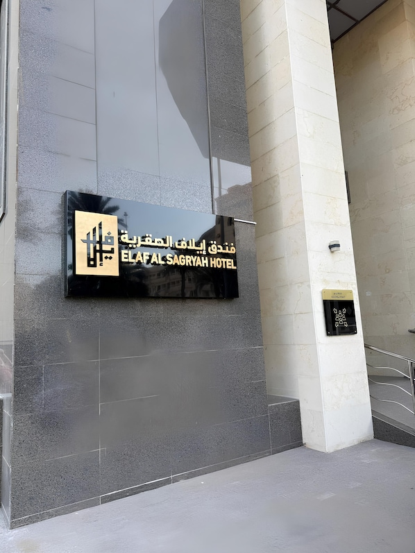 Entrada de un hotel con un cartel que dice ELAF AL SAGRYAH HOTEL.