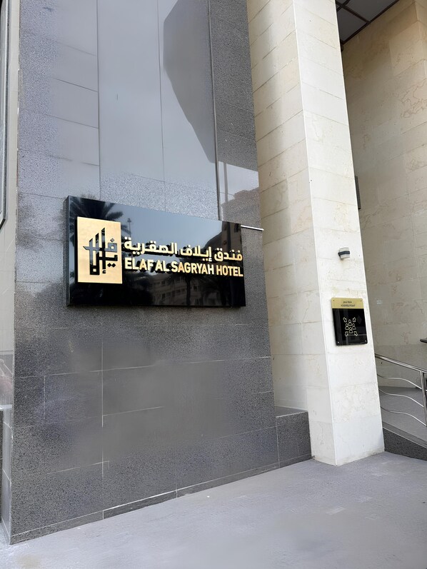 A hotel entrance with a sign for ELAF AL SAGRYAH HOTEL.