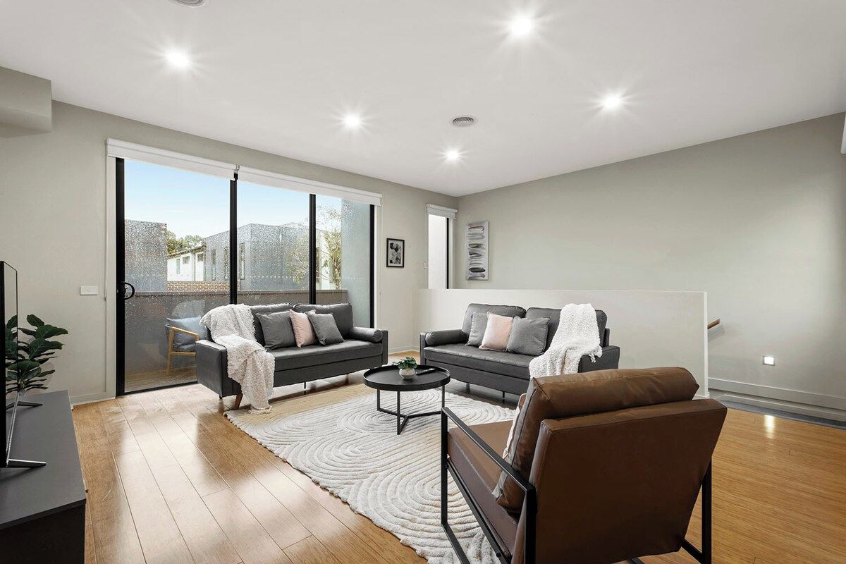A modern living room with two sofas, a coffee table, and a large window.