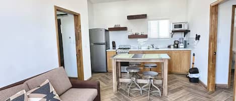 Een moderne keuken met een eethoek, een plafondventilator en een visgraatvloer.