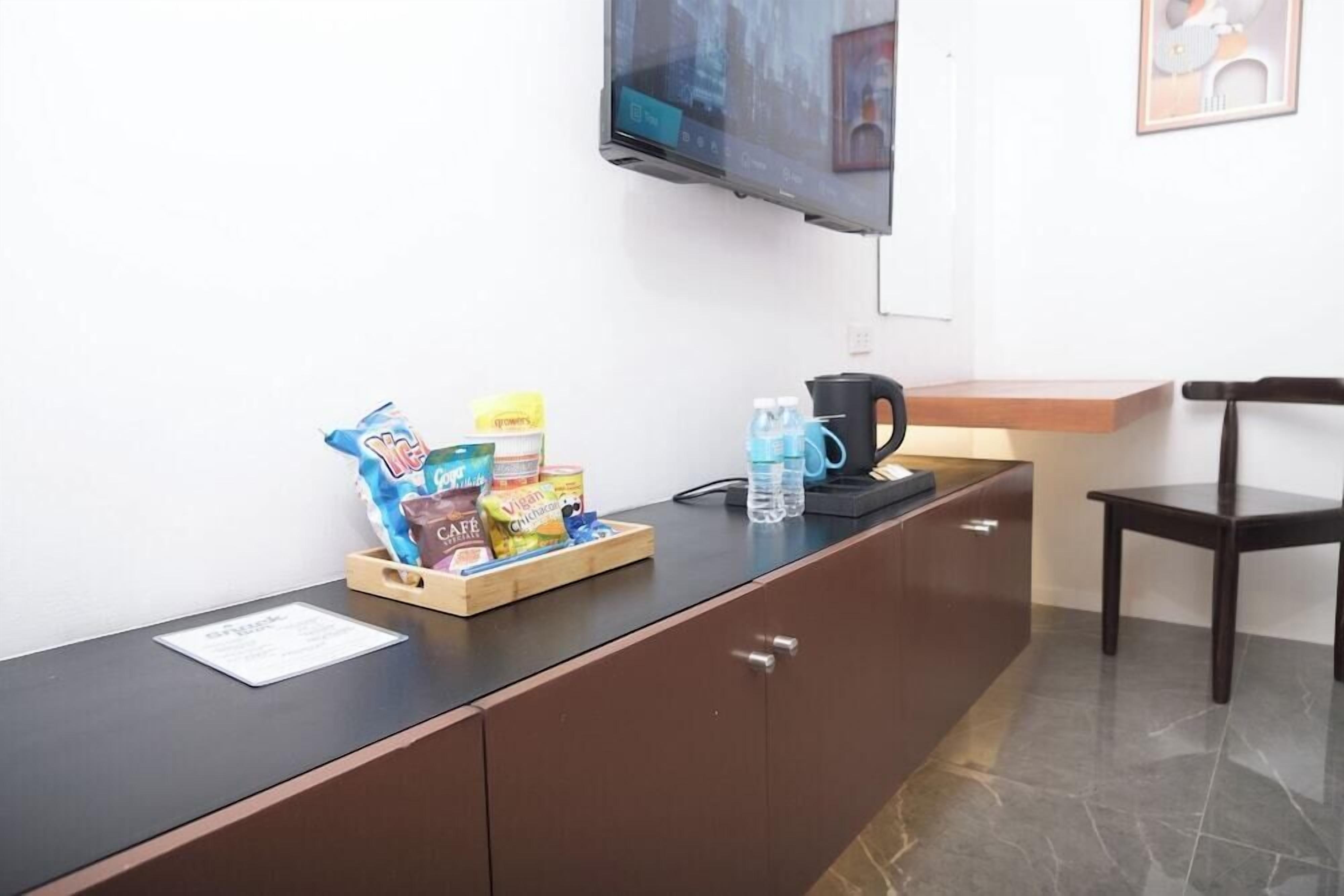 A reception desk with a tray of snacks, a water bottle, and a coffee maker.