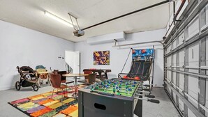 A room with a foosball table, a colorful rug, and a stroller. - 6 bedroom 6 Bath Palm Paradise close to Orlando Theme Parks (Kissimmee)