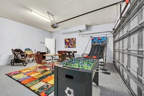 Ein Zimmer mit Kicker, farbenfroher Teppich und Kinderwagen.