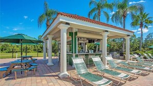 A covered outdoor seating area with lounge chairs and picnic tables. - 6 bedroom 6 Bath Palm Paradise close to Orlando Theme Parks (Kissimmee)