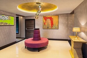 A modern interior with a circular seating area, a unique ceiling light, and artwork on the walls. - Justa Luxe Cliffend Resort and Spa Mashobra (Shimla)