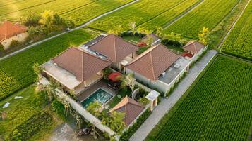 Una propiedad residencial con piscina, varios edificios y campos agrícolas circundantes.