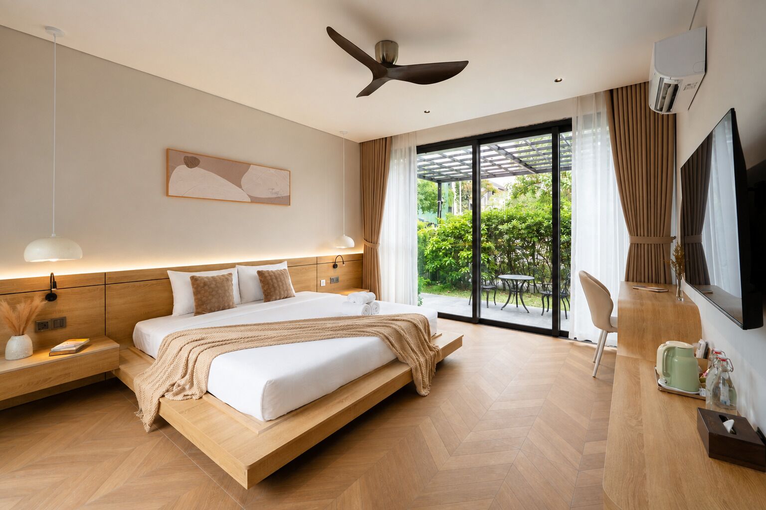 Habitación de hotel moderna con una cama grande, ventilador de techo, televisor y vistas al exterior.