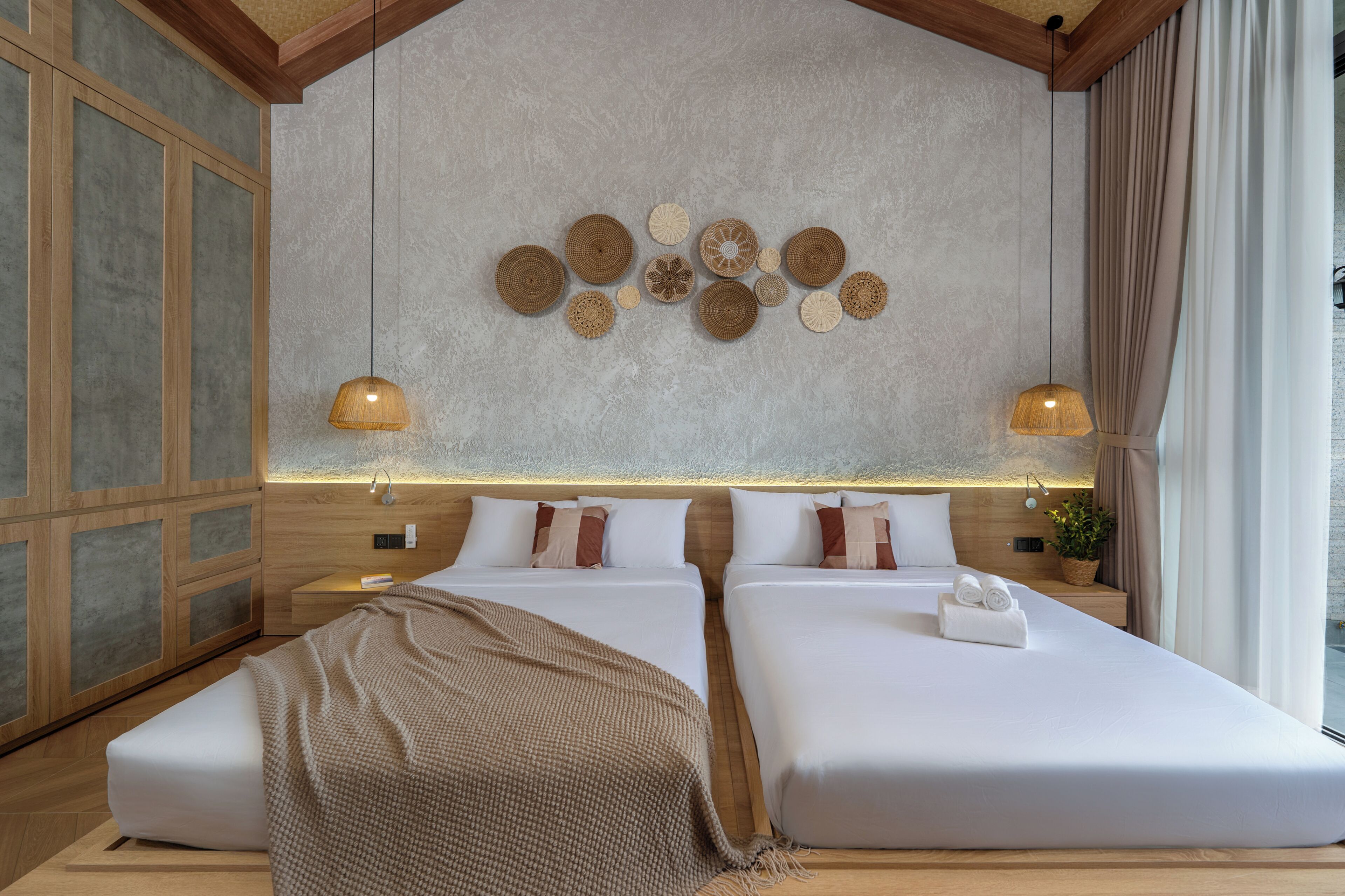 Habitación de hotel con dos camas, una decoración grande en la pared y vistas al exterior.