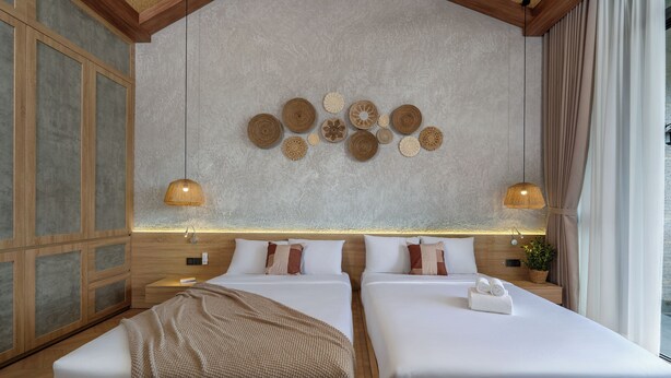Quarto de hotel com duas camas, uma grande decoração na parede e vista para o exterior.