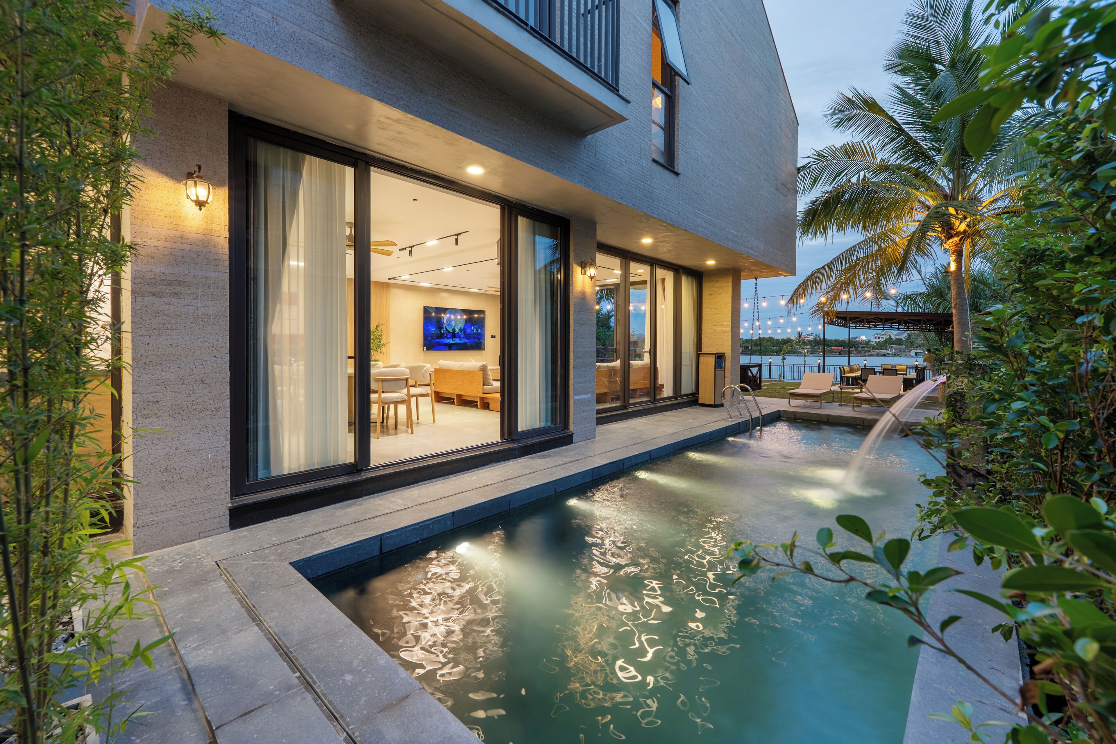 A modern building with a swimming pool, large windows, and a flat roof.