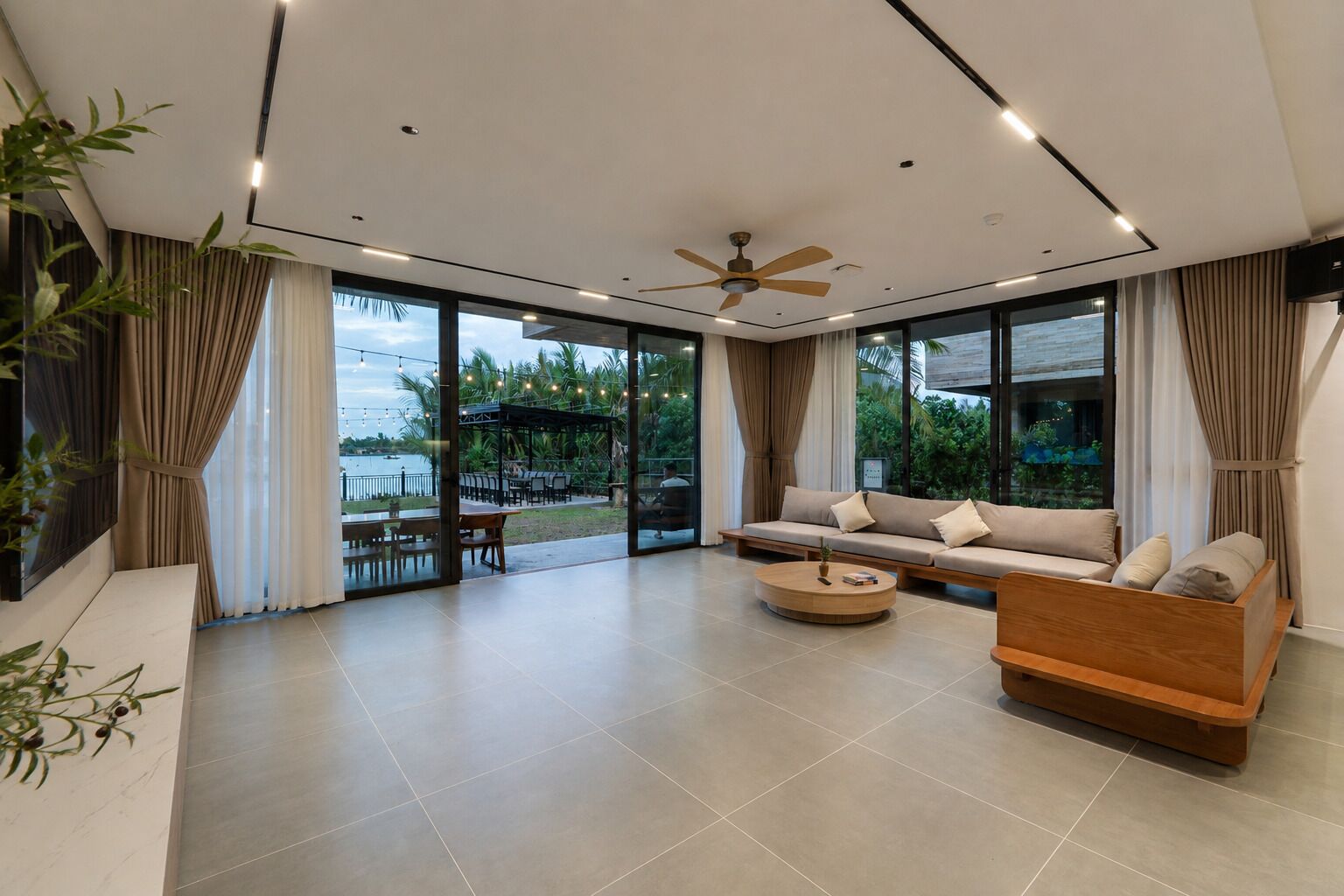A modern living room with a sofa, coffee table, and a ceiling fan.