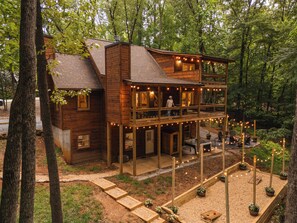 A wooden cabin with a balcony, a deck, and string lights. - New listing discount! Pickleball- Hot Tub- Gameroom- 6 min to town: all 5-stars! (Blue Ridge)