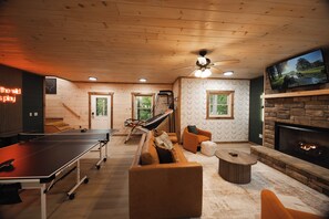 A cozy indoor space with a ping pong table, leather sofa, and a fireplace. - New listing discount! Pickleball- Hot Tub- Gameroom- 6 min to town: all 5-stars! (Blue Ridge)