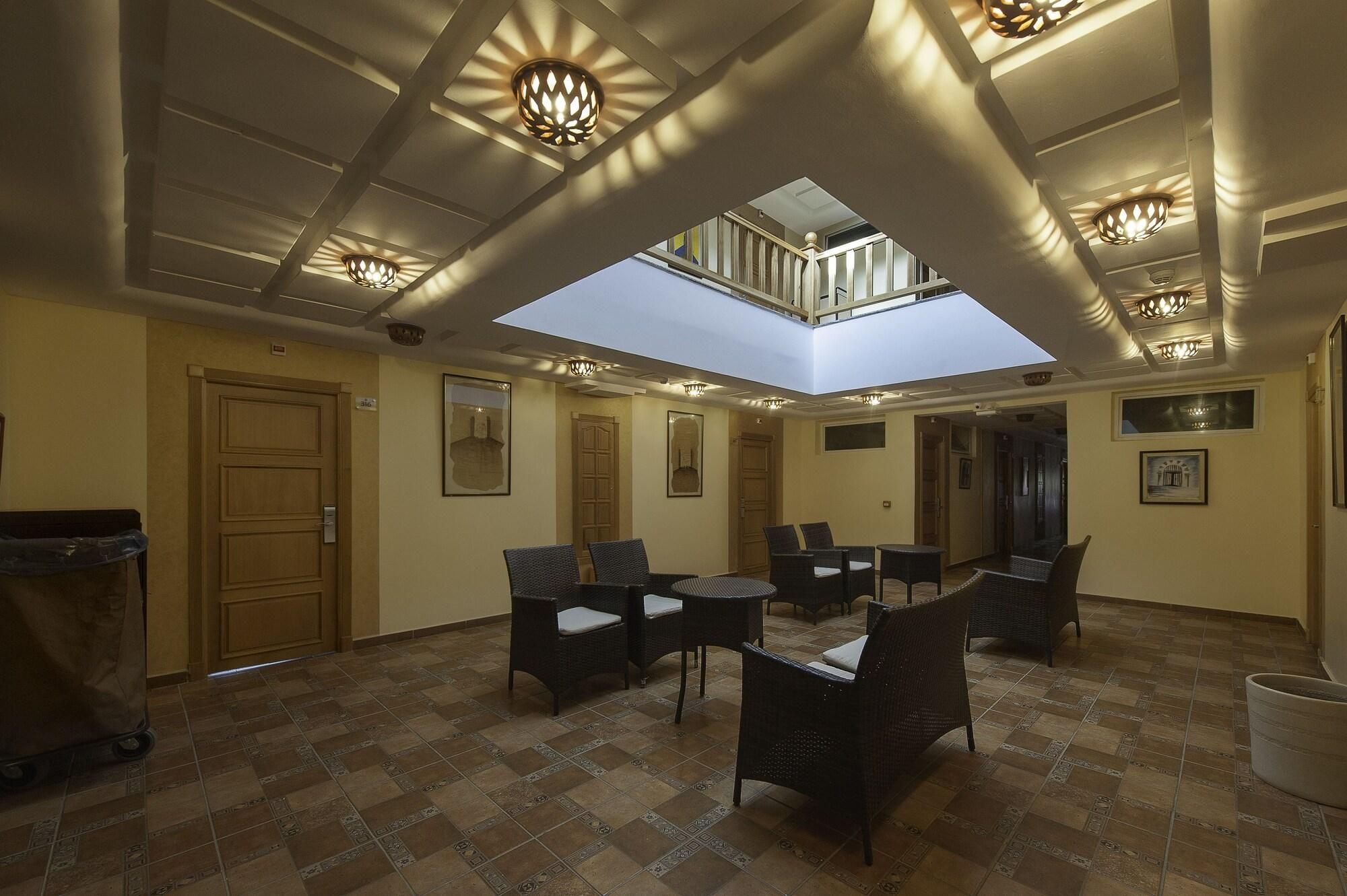 A spacious lounge area with a high ceiling, recessed lighting, and a skylight.