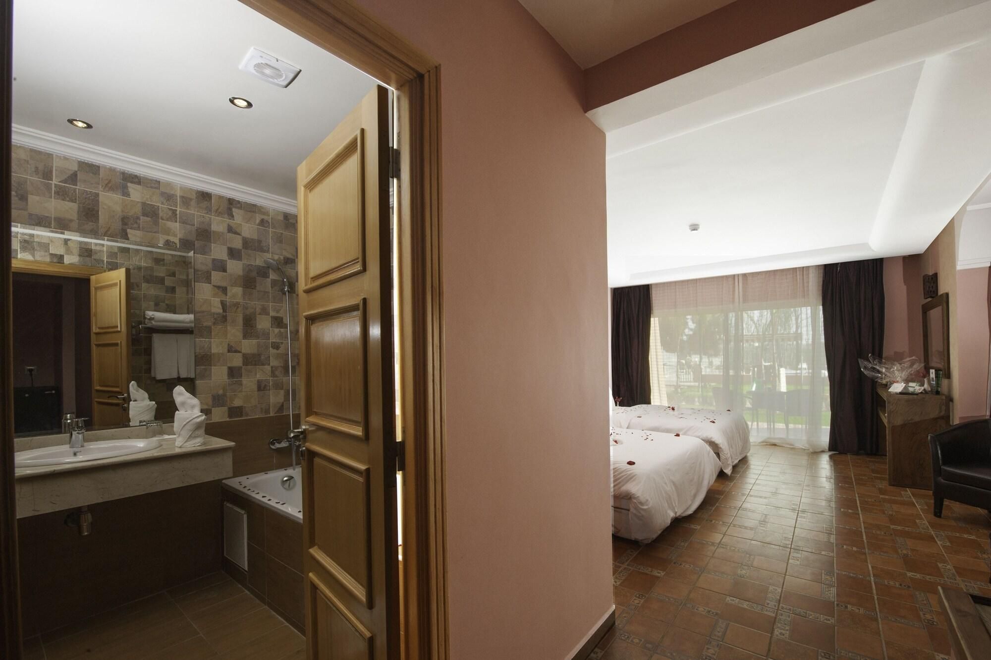 Una habitación de hotel con baño, cama y vistas al exterior.