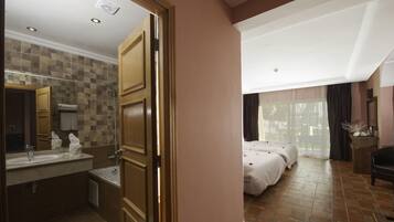 A hotel room with a bathroom, a bed, and a view of the outdoors.