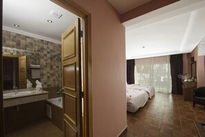 Una habitación de hotel con baño, cama y vistas al exterior.