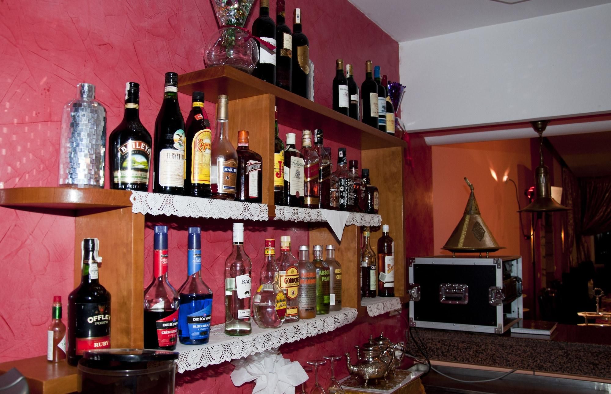 A bar area with shelves stocked with various liquor bottles.