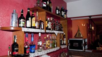A bar area with shelves stocked with various liquor bottles.