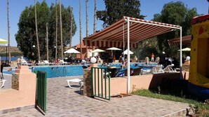 A pool area with multiple pools, umbrellas, and lounge chairs.