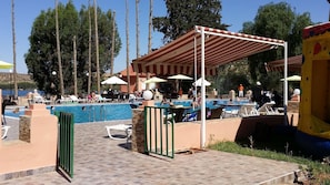 A pool area with multiple pools, umbrellas, and lounge chairs. - Dar Eddaya Hôtel (Oulmes)