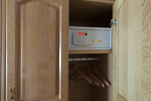 A wooden wardrobe with a digital lock and a hanging rack inside.