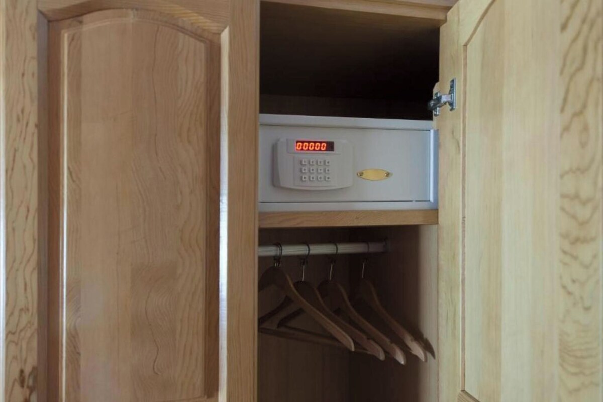 Un armario de madera con cerradura digital y un juego de perchas.