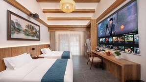 A hotel room with two beds, a large TV screen displaying a movie, and a wooden ceiling. - Zhangjiajie Valley Love Holiday Hotel (Zhangjiajie)