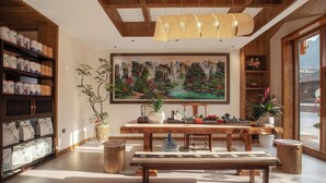A traditional-style room with a wooden ceiling, a large painting, a dining table with chairs, and shelves with items. - Zhangjiajie Valley Love Holiday Hotel (Zhangjiajie)