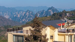 Ein Wohngebäude mit Balkon, Bergblick und traditioneller Architektur.