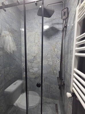 A shower enclosure with a glass door, a handheld showerhead, and a wall-mounted faucet. - Hotel Corner (Batumi)