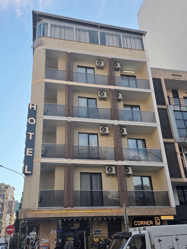 A multi-story hotel with balconies, air conditioning units, and a visible entrance. - Hotel Corner (Batumi)