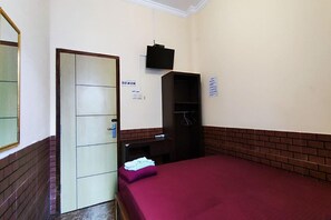 A room with a bed, a wardrobe, a mirror, and a door. - Oyo 93749 Aksana Homestay Syariah (Purwokerto)