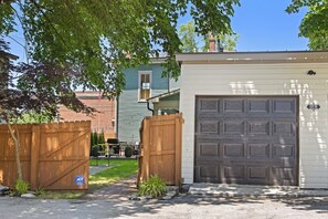 A residential garage with a dark door, a wooden fence, and a mailbox. - 2mi to Buffalo Trace > GameRoom > HotTub > FirePit (Frankfort)