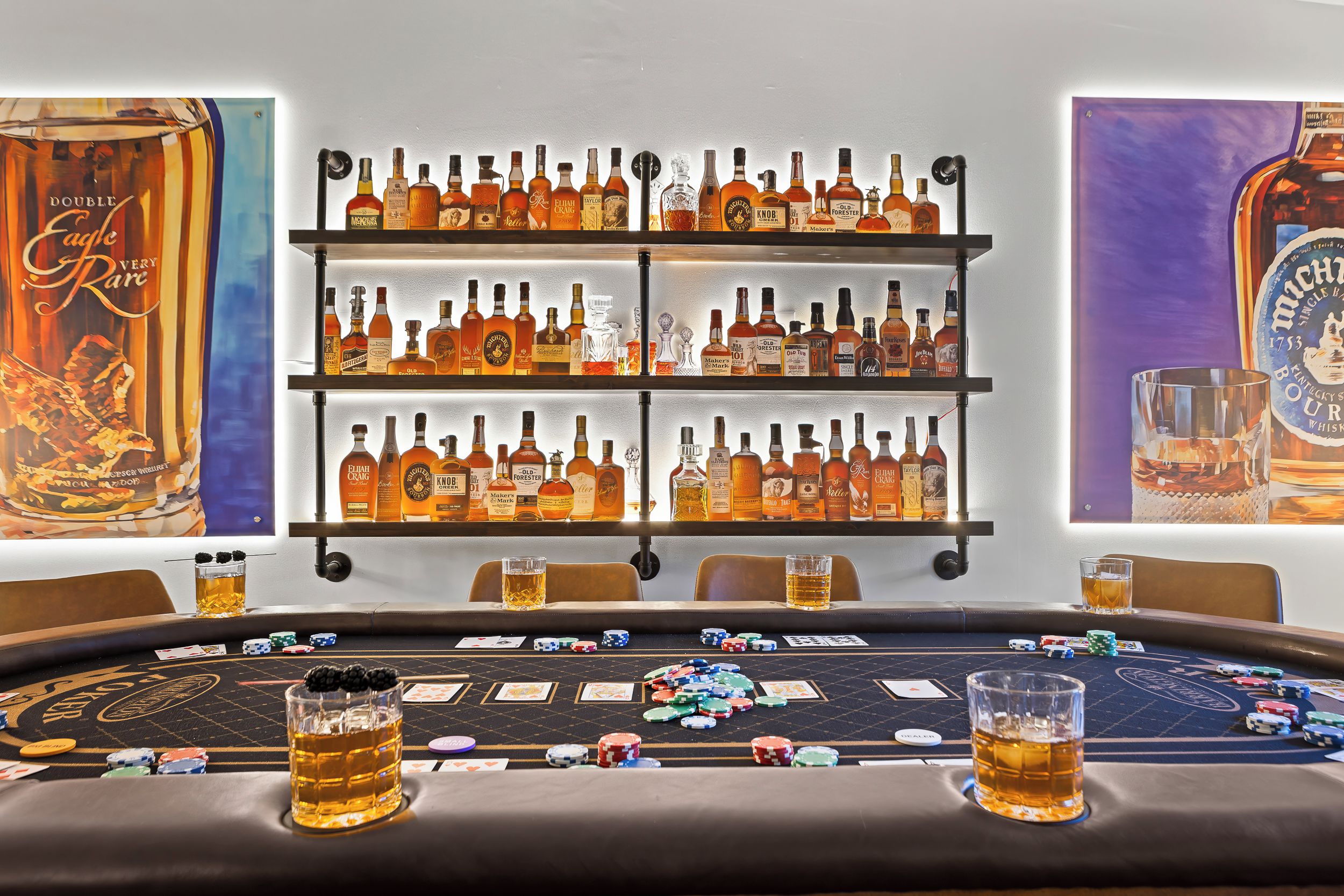 Une table de jeu de casino avec des jetons de poker et des cartes, entourée d’étagères remplies de différentes bouteilles d’alcool.