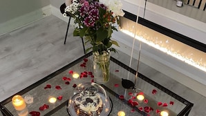 A glass-top table with candles, a cake, and a welcome sign. - Inviting 1 Bed House In Bradford (Bradford)