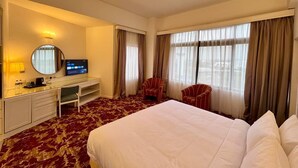 A hotel room with a large bed, a desk with a computer, a chair, and a television. - Royal Park Hotel (Kajang)