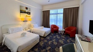 A hotel room with two beds, a desk, a chair, and a television. - Royal Park Hotel (Kajang)