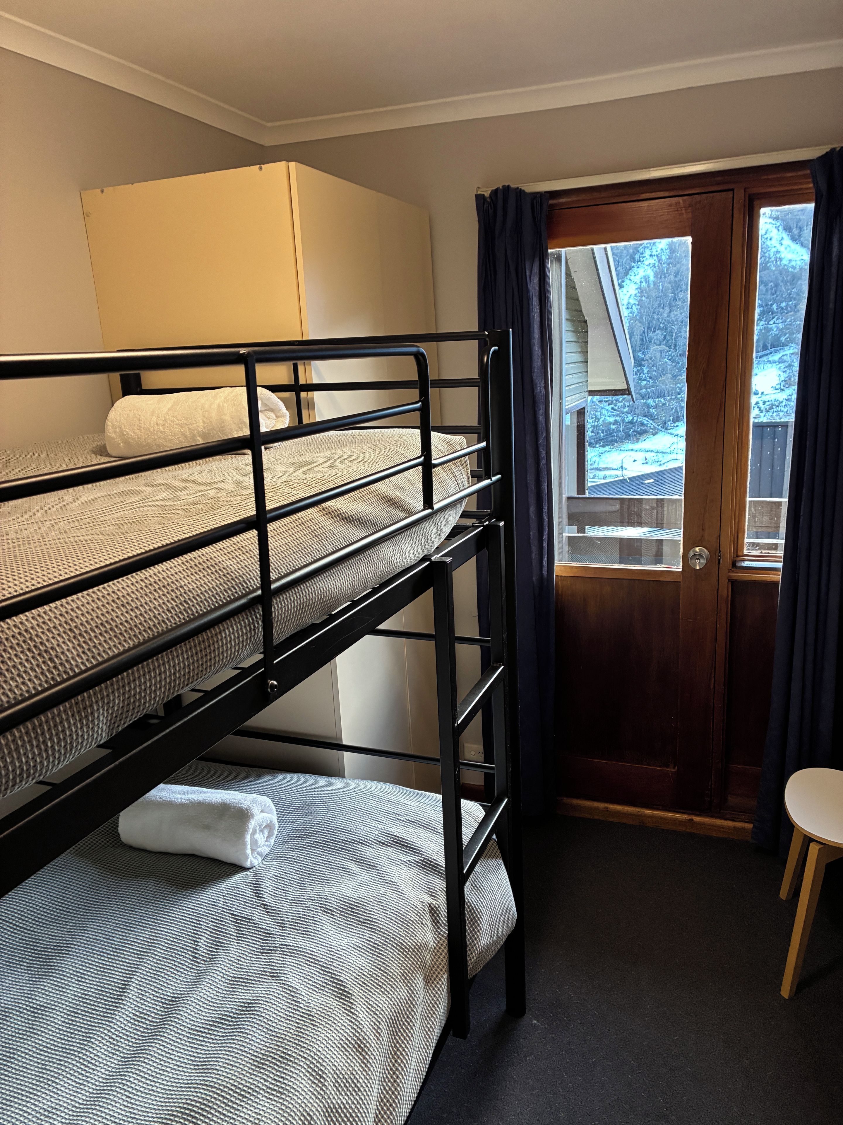 A bunk bed room with a door and a small table.