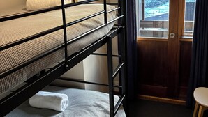 A bunk bed room with a door and a small table.