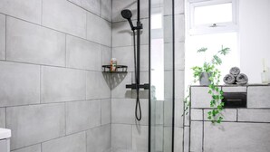 A modern bathroom with a glass shower enclosure, a white toilet, and a grey tiled wall. - 3-bedroom House Bolton Town Centre Free Parking (Bolton)