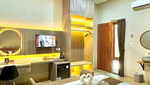 Ein Hotelzimmer mit einem Bett, einem Schreibtisch, einem Fernseher und einem Spiegel.