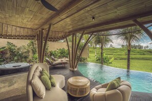 A poolside area with lounge chairs, a hot tub, and a view of a lush landscape. - Equipoise Resort Ubud by Ini Vie Hospitality (Tegallalang)