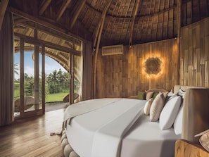 A bedroom with a large bed, wooden walls, a ceiling fan, and a view of the outdoors. - Equipoise Resort Ubud by Ini Vie Hospitality (Tegallalang)