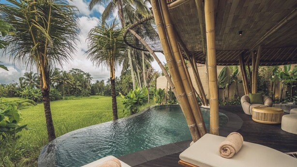 A poolside area with lounge chairs, a bamboo structure, and a view of a lush green landscape. - Equipoise Resort Ubud by Ini Vie Hospitality (Tegallalang)