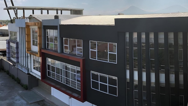 Un bâtiment moderne doté de nombreuses fenêtres et d’un toit plat.