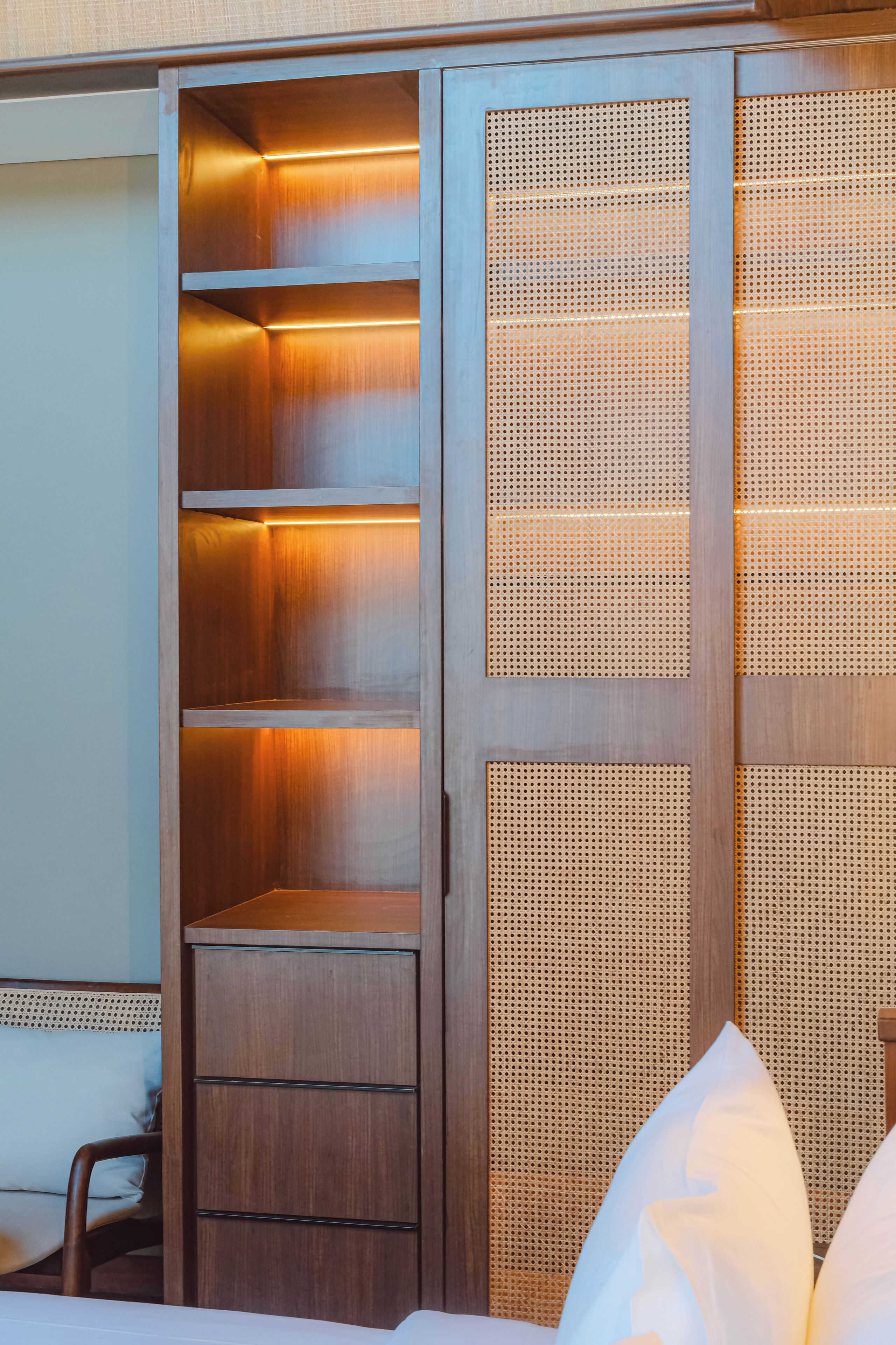 Habitación de hotel con armario empotrado que incluye estantes y cajones.