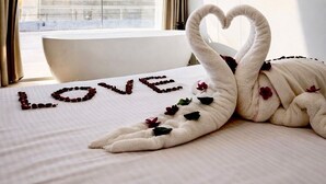 Een hotelkamer met een bed, een handdoek in de vorm van een hart en uitzicht op een piramide.