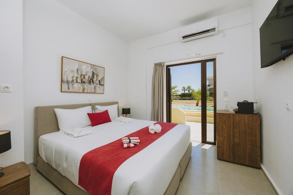 A hotel room with a bed, a painting, a desk, and a view of a pool.